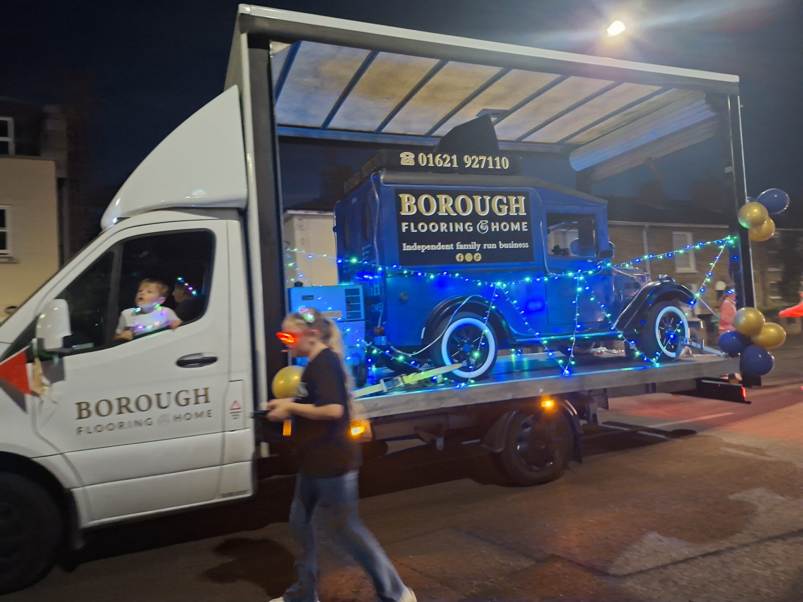Borough Flooring and Home illuminated carnival entry with a blue vintage vehicle